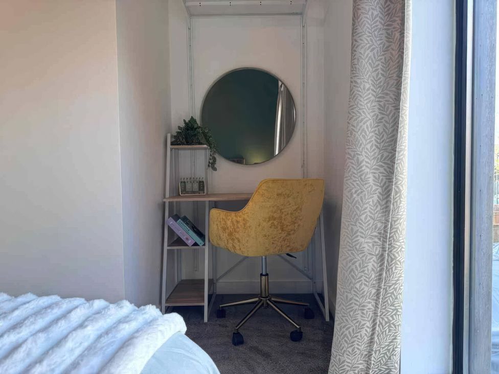 An office space with a desk, chair, and mirror at 11 Radclyffe Mews in Salford