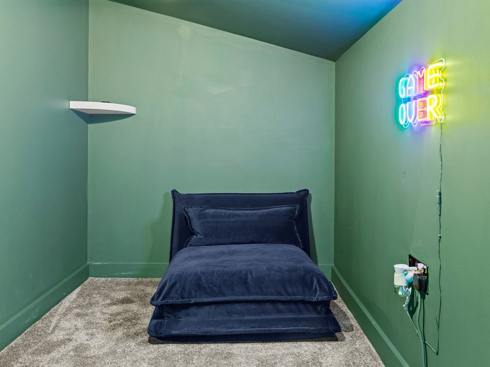 A snug with a bed and a neon sign at 11 Radclyffe Mews Salford