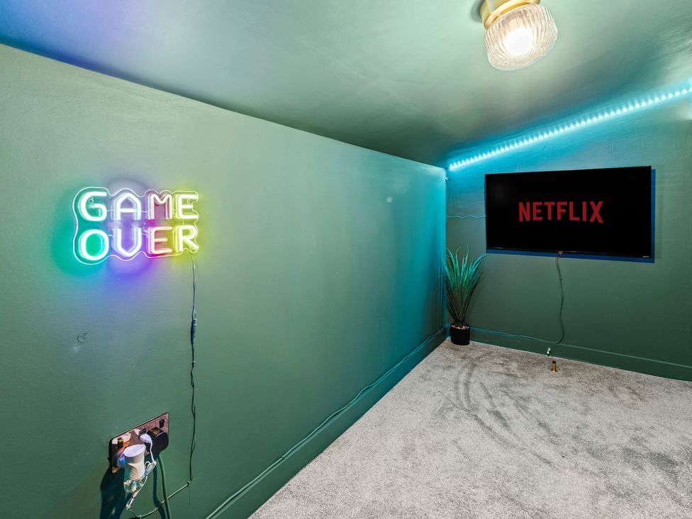 A snug with a neon sign and a television at 11 Radclyffe Mews Salford