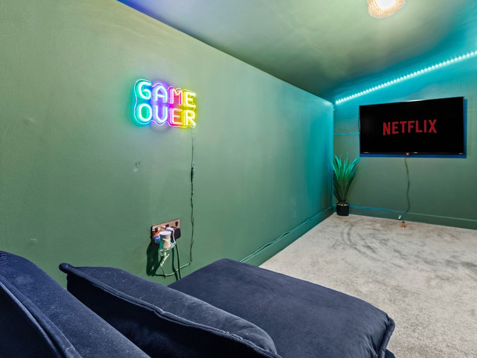 A snug with a television and a neon sign at 11 Radclyffe Mews in Salford