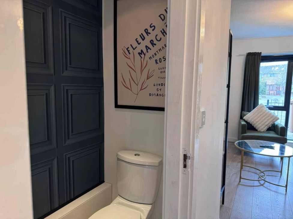 A bathroom with a toilet and wall paneling at 11 Radclyffe Mews in Salford
