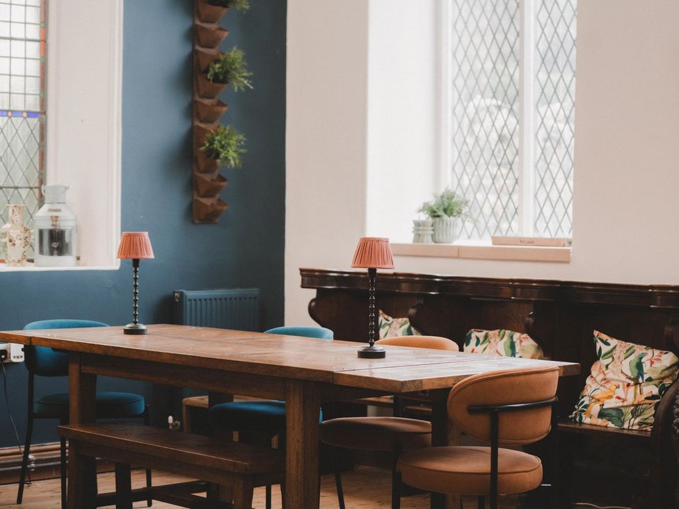 A dining room with a wooden table and chairs at Chapel of Arts in Criccieth