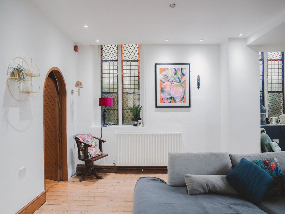 A living room with a window and artwork at Chapel of Arts in Criccieth