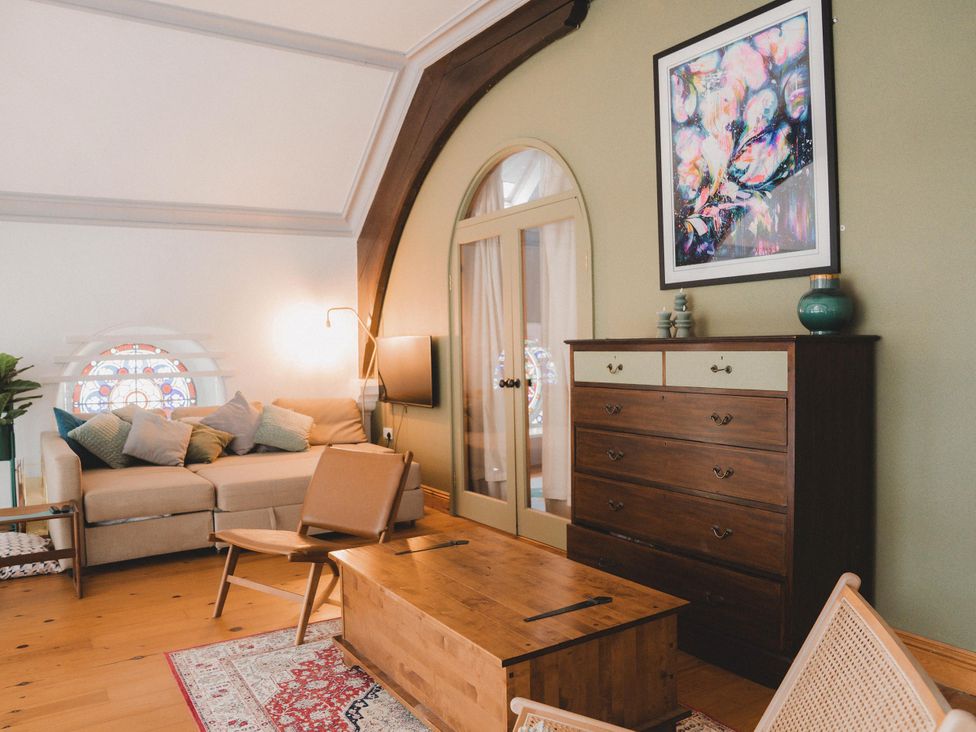 A living room with a sofa and coffee table at Chapel of Arts in Criccieth