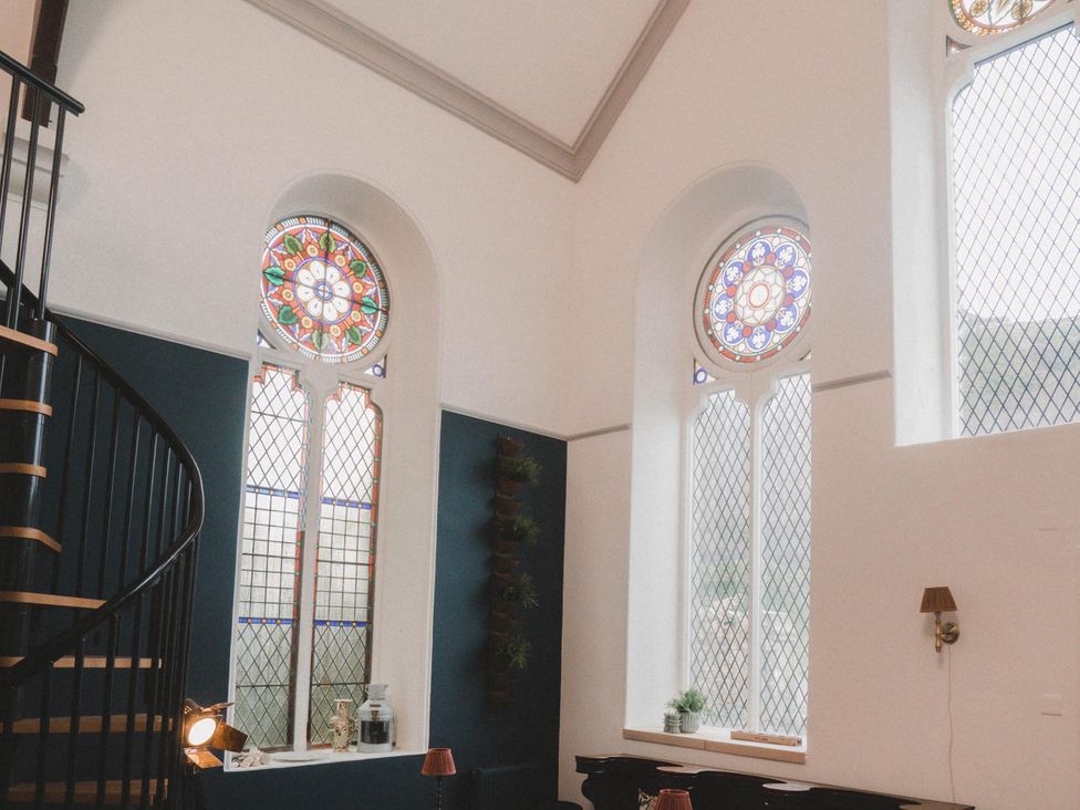 A room with a spiral staircase and stained glass windows at Chapel of Arts in Criccieth