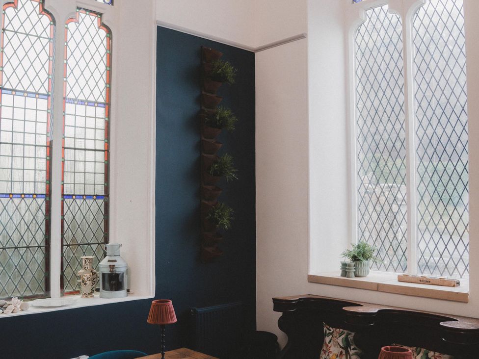 A room with stained glass windows and plants at Chapel of Arts in Criccieth