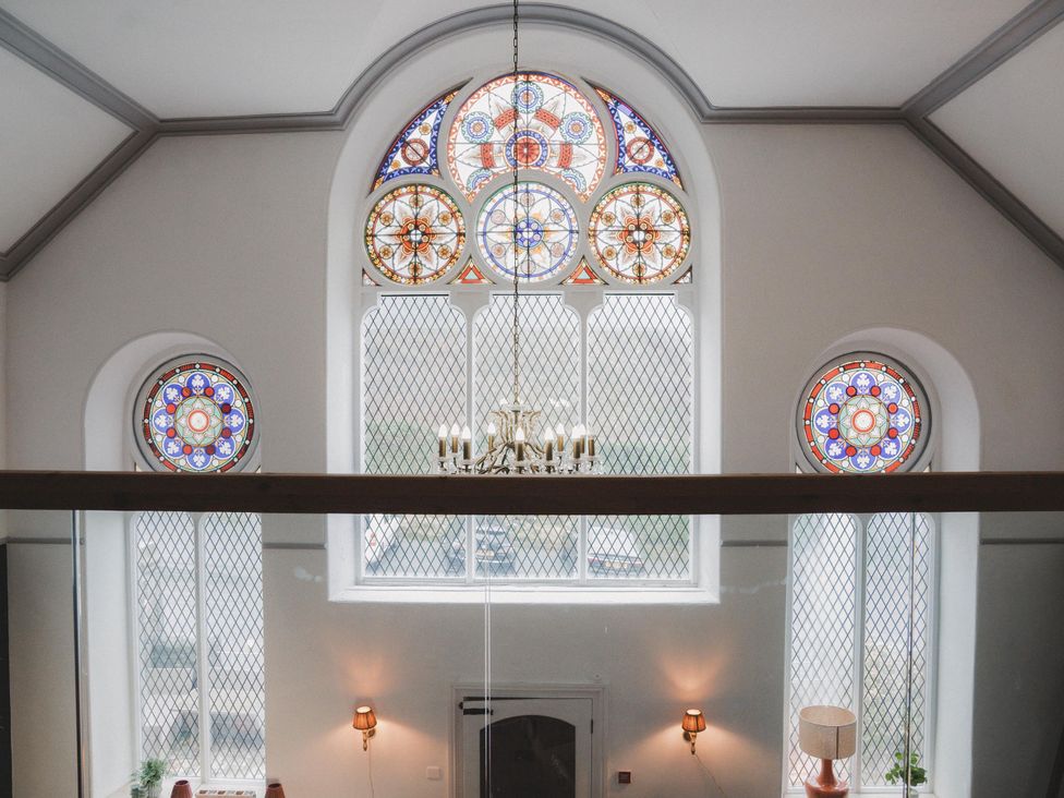 An indoor space with stained glass windows and chandelier at Chapel of Arts Criccieth