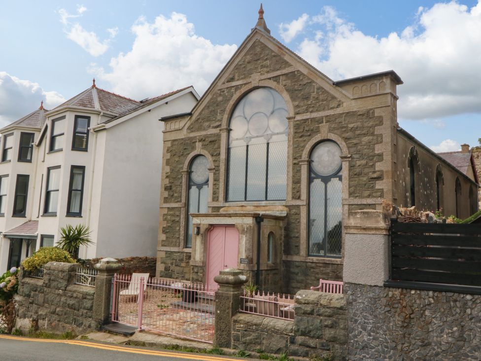 A church building with a pink door and large windows at Chapel of Arts in Criccieth