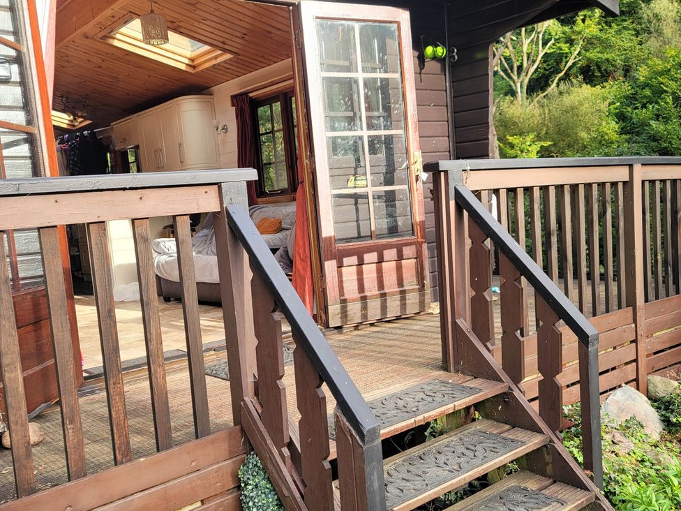 An entrance with a wooden deck and stairs leading to a living area at River Lodge in Lynbridge near Lynmouth