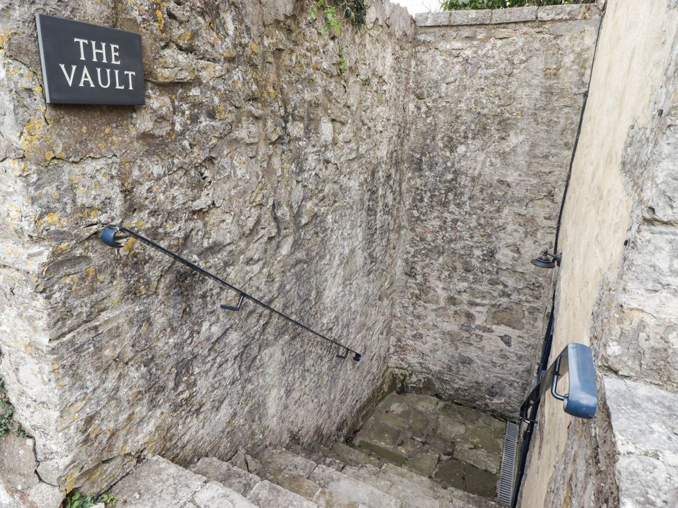 An outdoor stairway with stone walls and a sign at The Vault Hotel Room in Gileston near St Athan
