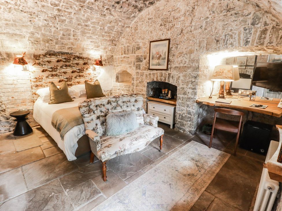 A bedroom with a bed and desk at The Bakery Hotel Room in Gileston near St Athan