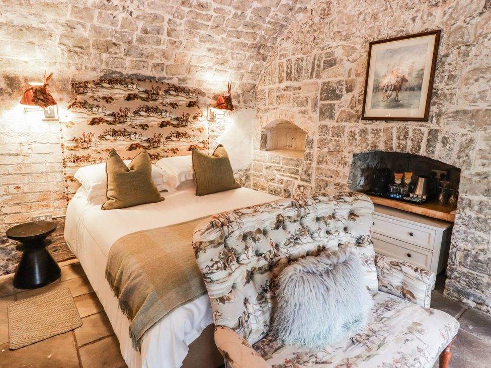 A bedroom with a bed and seating at The Bakery Hotel Room in Gileston near St Athan