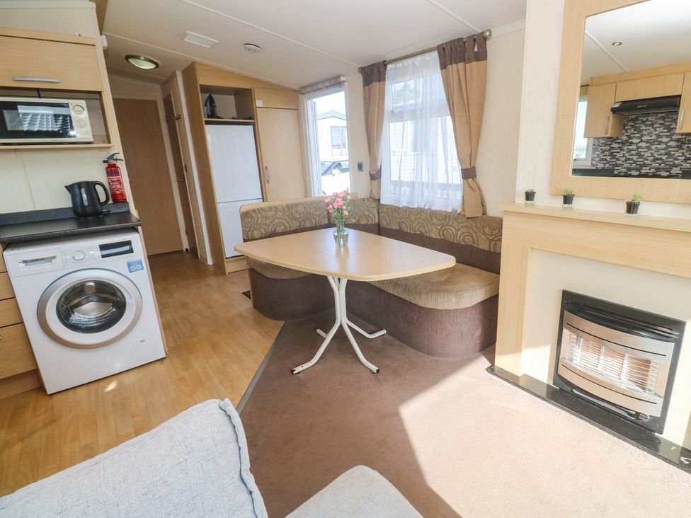 A living room with a table and sofa at No.73 Sennen Cove