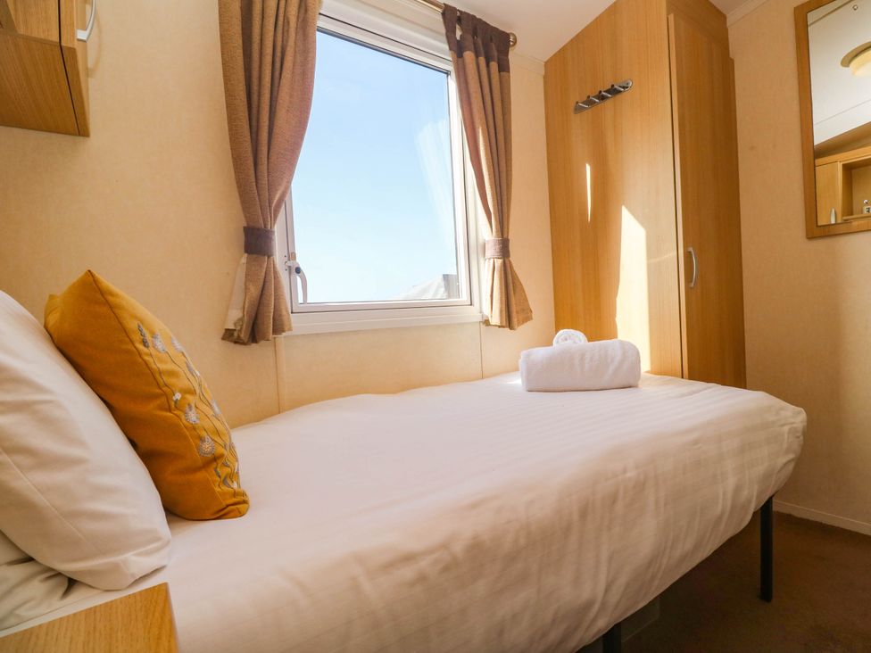 A bedroom with a bed and window at No.73 Sennen Cove