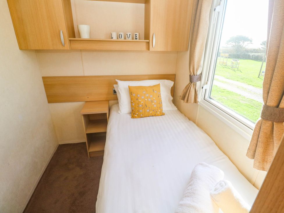 A bedroom with a single bed and shelves at No.73 Sennen Cove