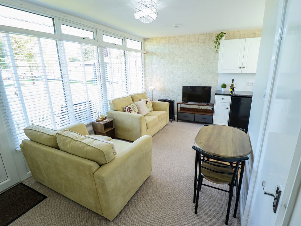 A living room with sofa and television at Cherry Park Retreat in Skegness