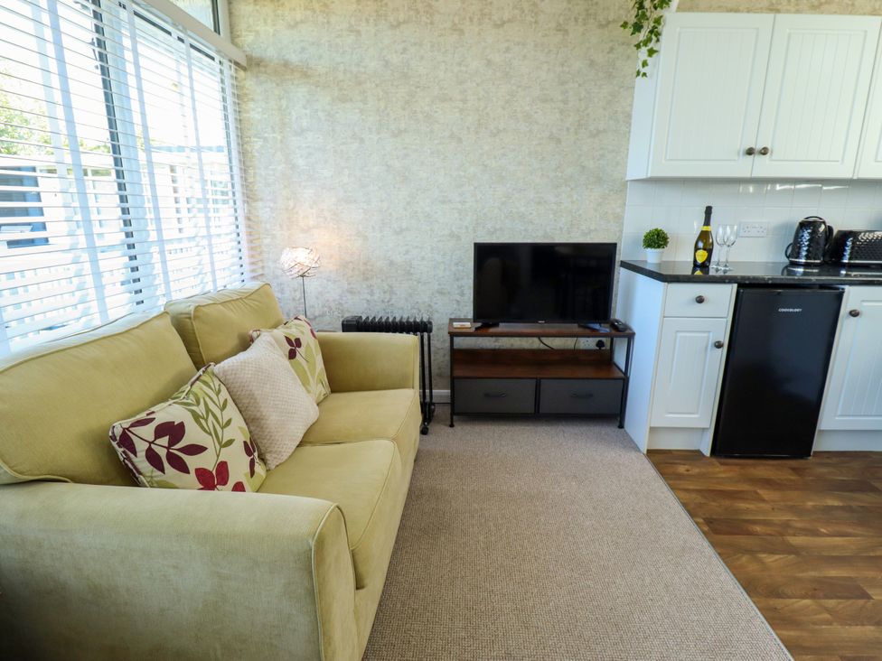 A living room with a sofa and television at Cherry Park Retreat in Skegness
