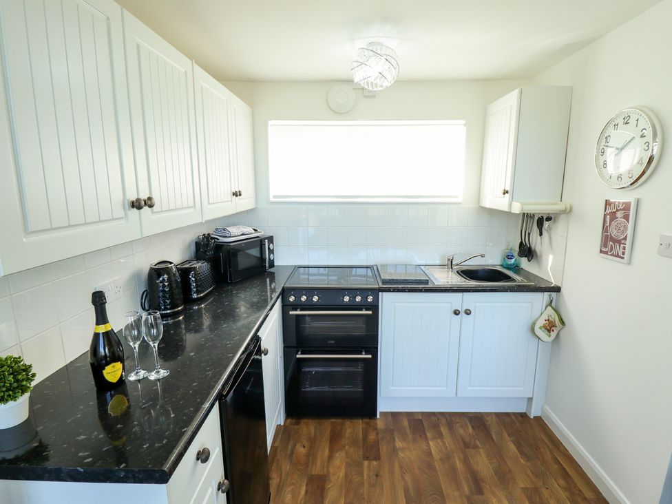 A kitchen with an oven and microwave at Cherry Park Retreat in Skegness
