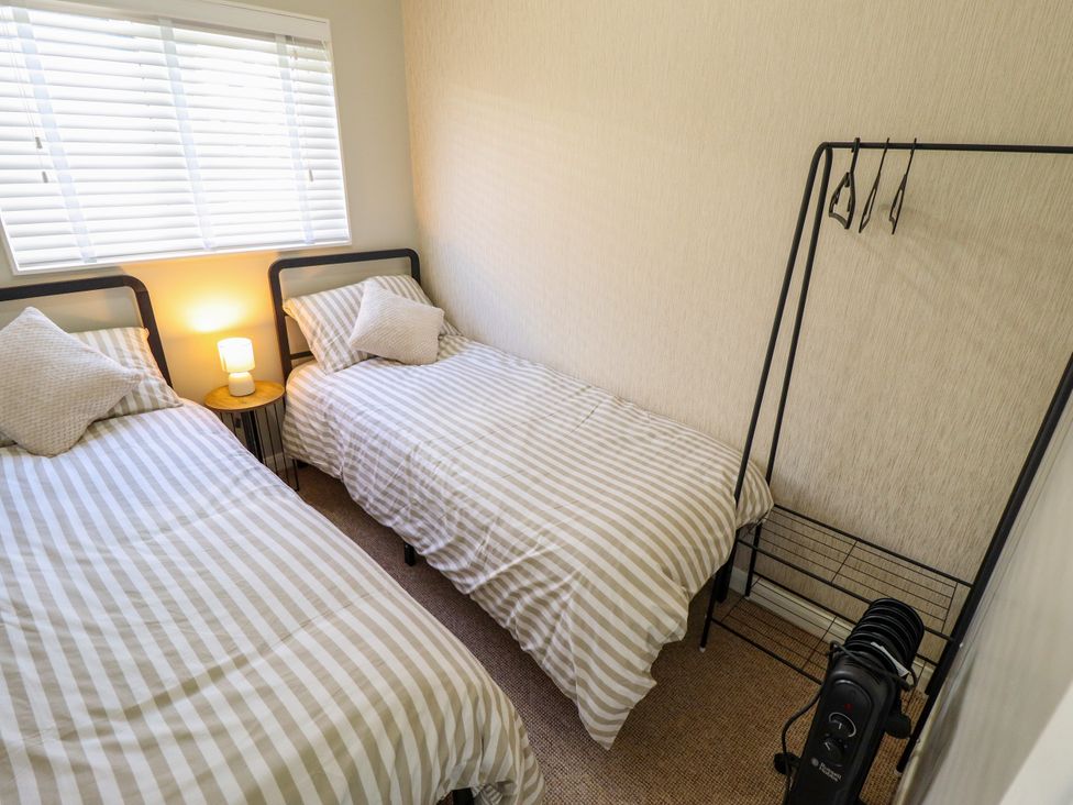 A bedroom with two beds and a lamp at Cherry Park Retreat in Skegness