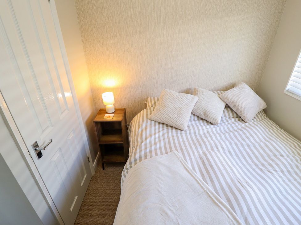 A bedroom with a bed and lamp at Cherry Park Retreat in Skegness