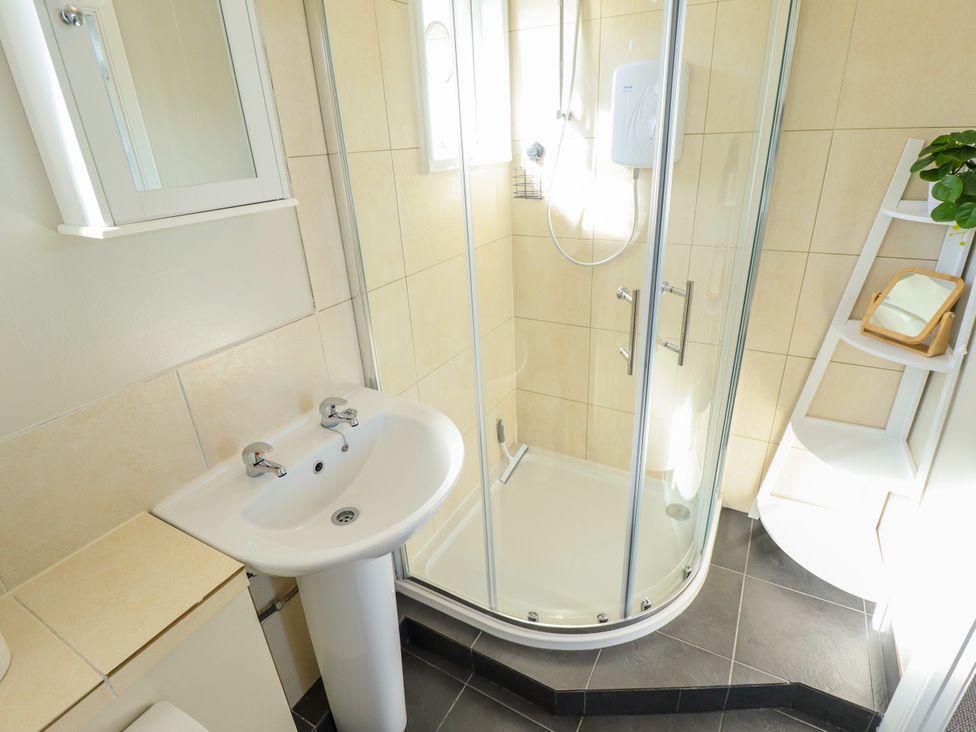 A bathroom with a shower and sink at Cherry Park Retreat in Skegness