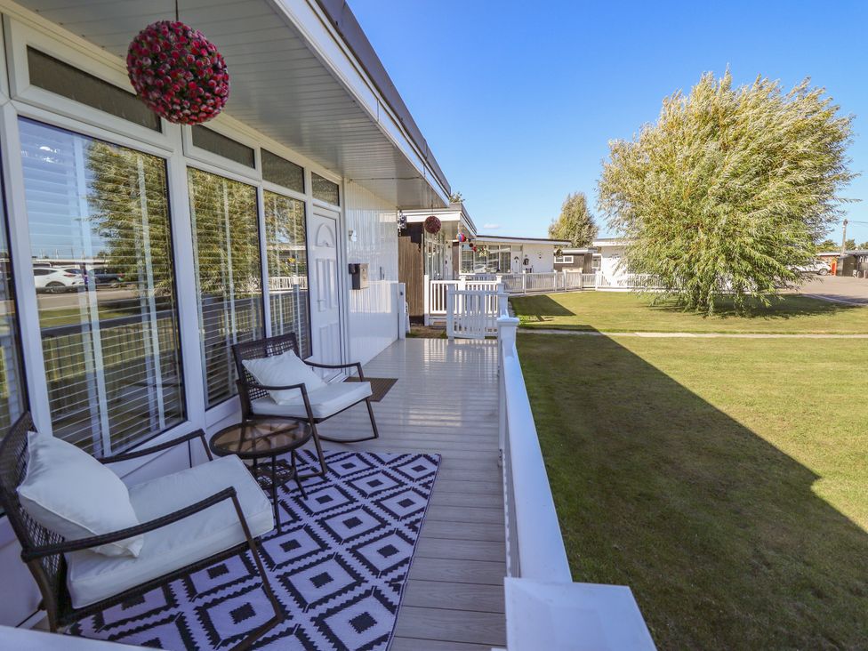 An outdoor area with chairs and a table at Cherry Park Retreat in Skegness