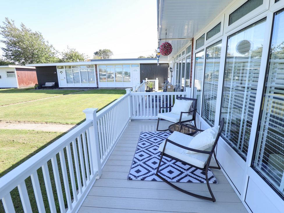 A deck with chairs and a rug at Cherry Park Retreat in Skegness