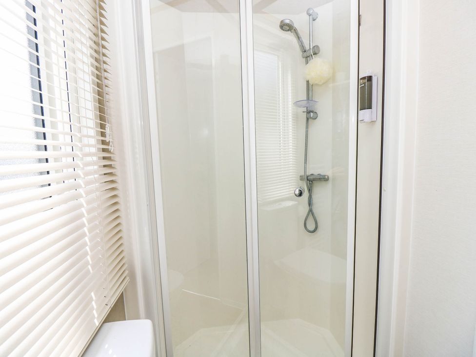 A shower enclosure with a shower head in 216 Solent Breezes Southampton