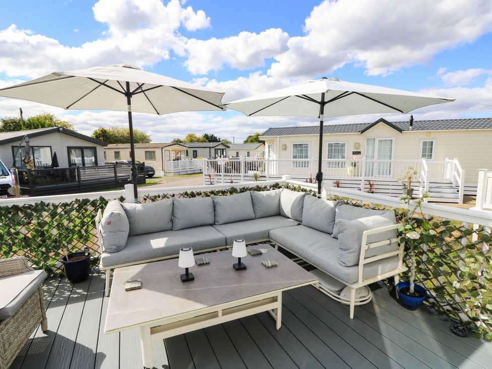 An outdoor seating area with sofas and umbrellas at 216 Solent Breezes Southampton