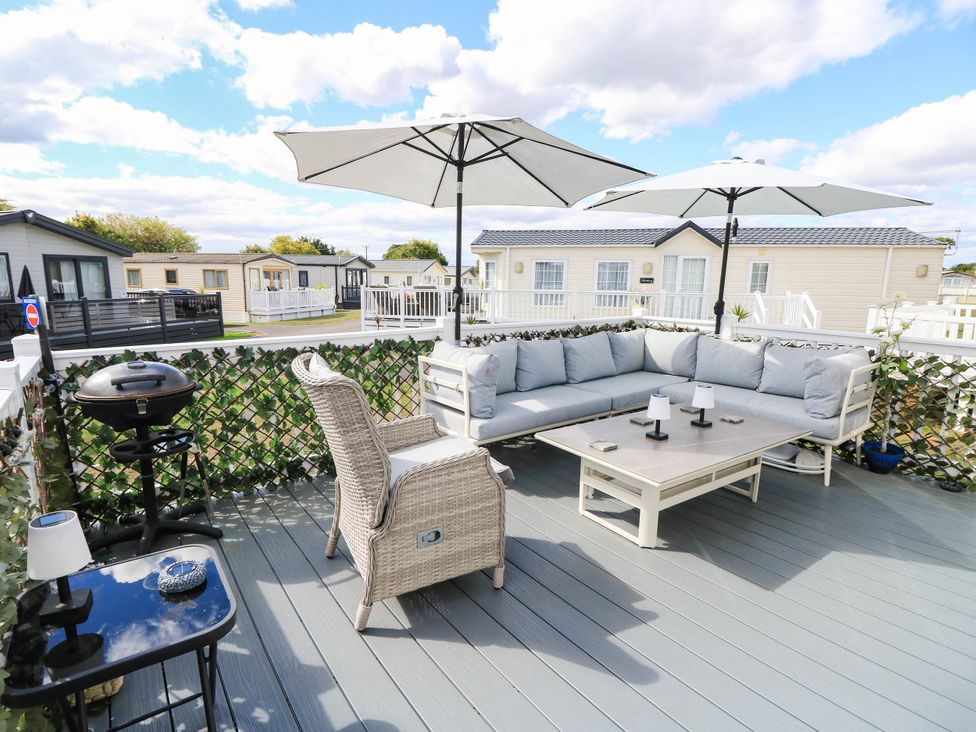 An outdoor area with a couch and table under umbrellas at 216 Solent Breezes Southampton