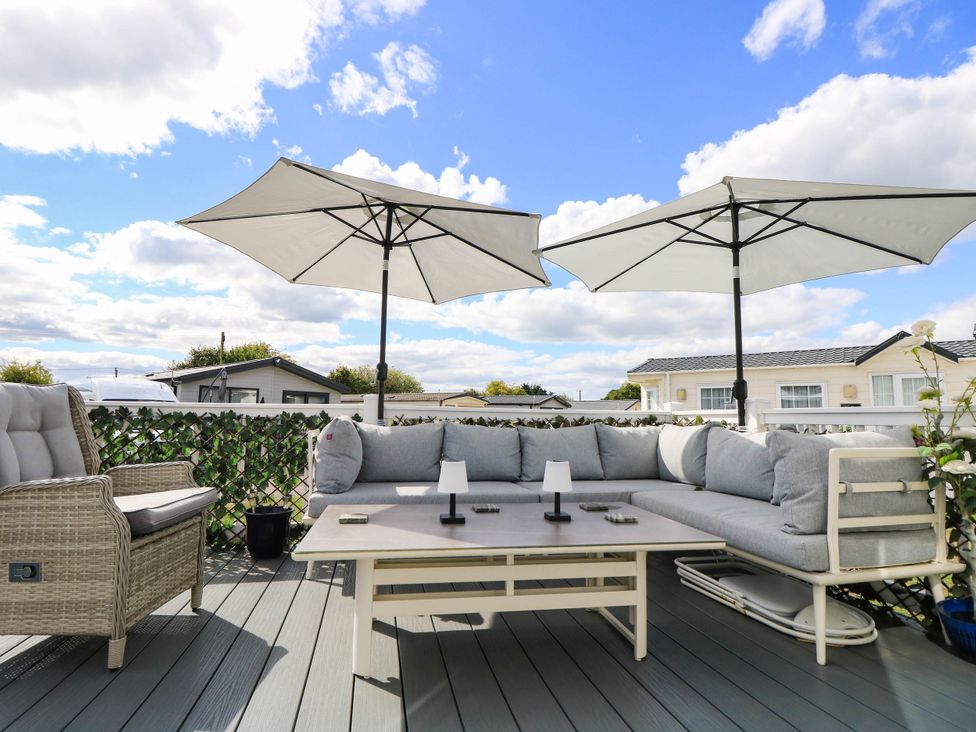 A patio with outdoor furniture and umbrellas at 216 Solent Breezes Southampton