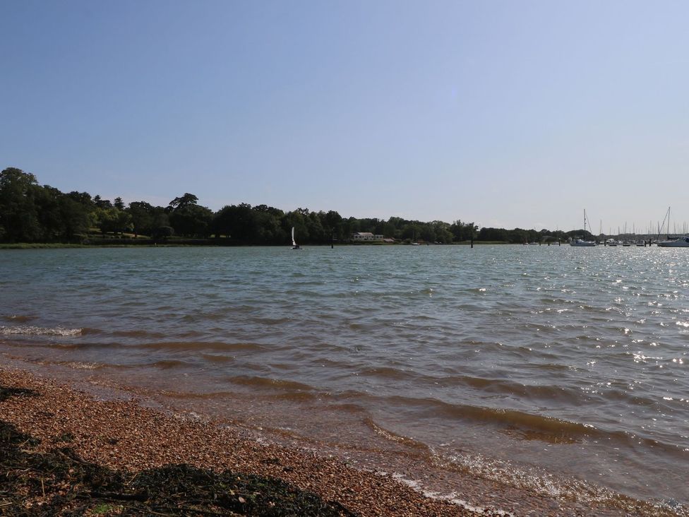 A beach with water and a sailing boat at 216 Solent Breezes Southampton
