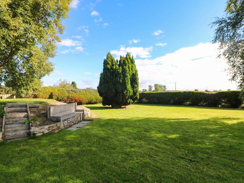 A garden with a stone wall and bench at Kate’s in Daingean