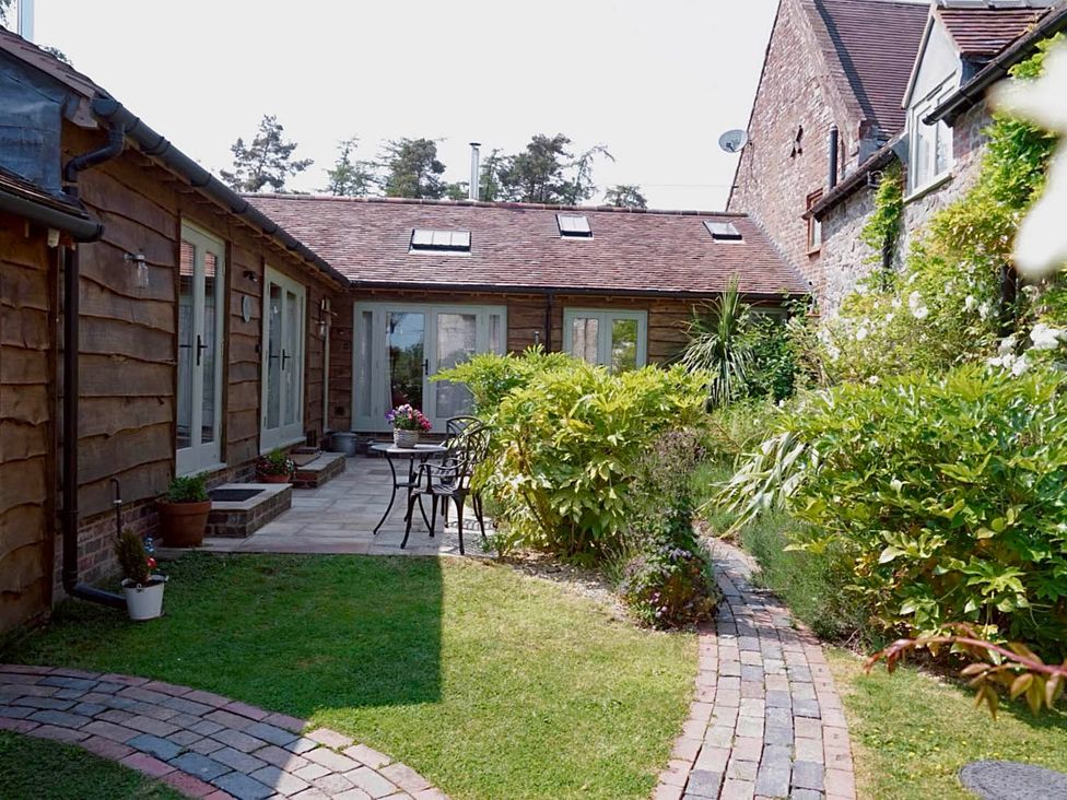 A garden area with a pathway and seating at Nest Holiday Hideaway Wren Cottage Stunning Area Picklescott near Church Stretton