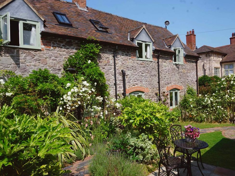 An exterior view of a stone building with windows and a garden at Nest Holiday Hideaway Wren Cottage Stunning Area, Picklescott near Church Stretton