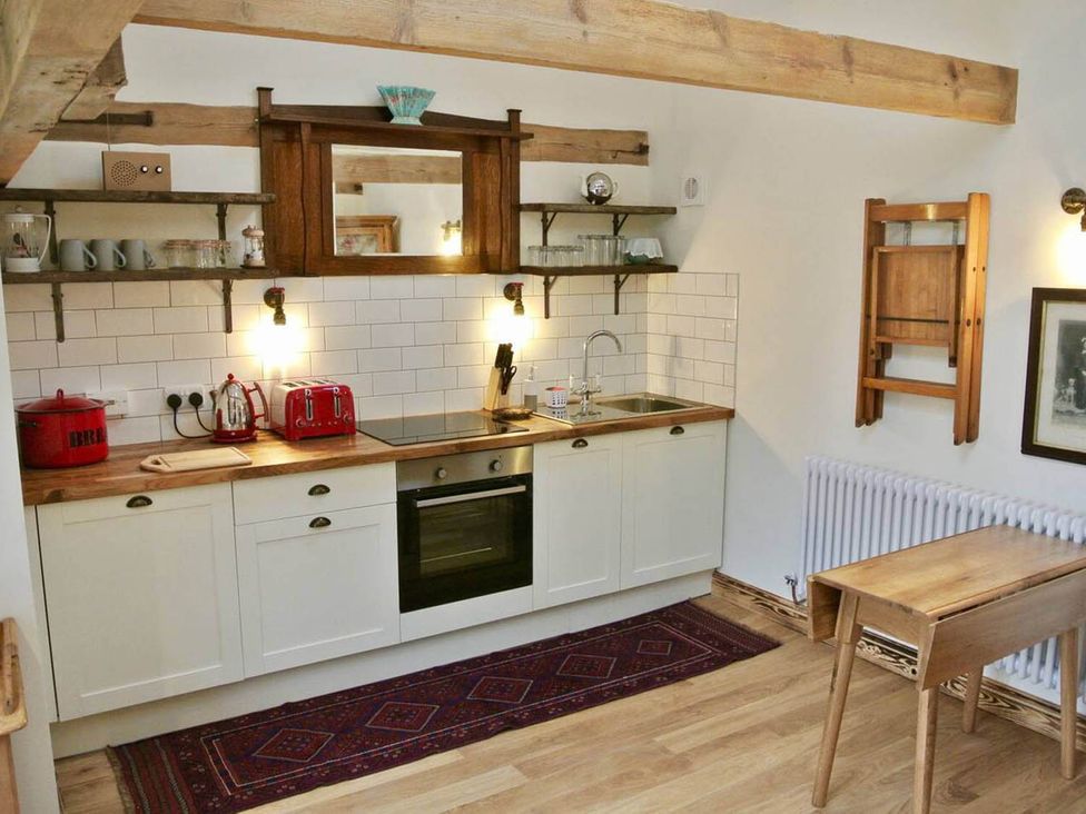 A kitchen with cabinets and shelves at Nest Holiday Hideaway Wren Cottage Stunning Area near Picklescott