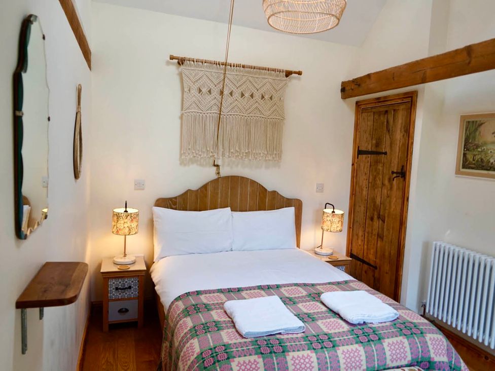 A bedroom with a bed and bedside table at Nest Holiday Hideaway Wren Cottage Stunning Area, Picklescott near Church Stretton
