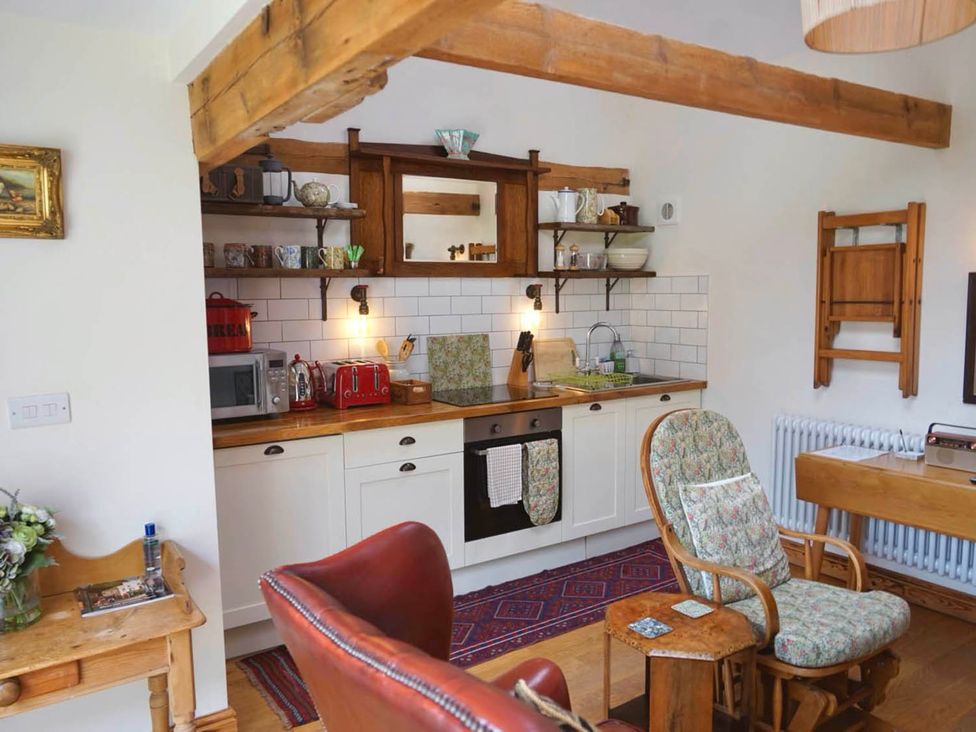 A kitchen with cabinets and appliances at Nest Holiday Hideaway Wren Cottage Stunning Area Picklescott near Church Stretton