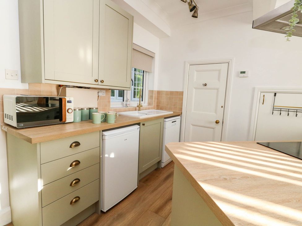 A kitchen with a microwave and refrigerator at Osmington Cottage Annex