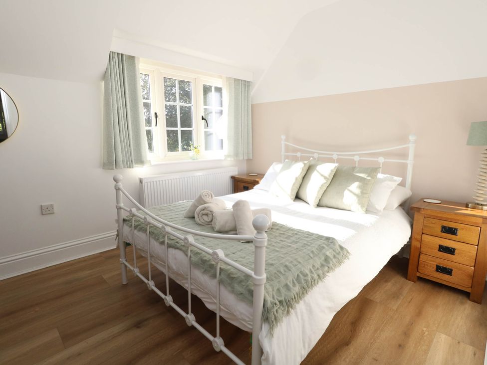 A bedroom with a bed and bedside tables at Osmington Cottage Annex 