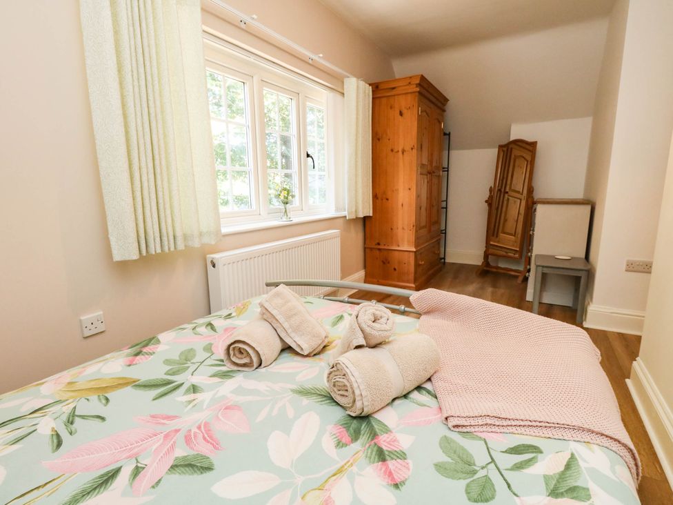 A bedroom with a bed and wardrobe at Osmington Cottage Annex 