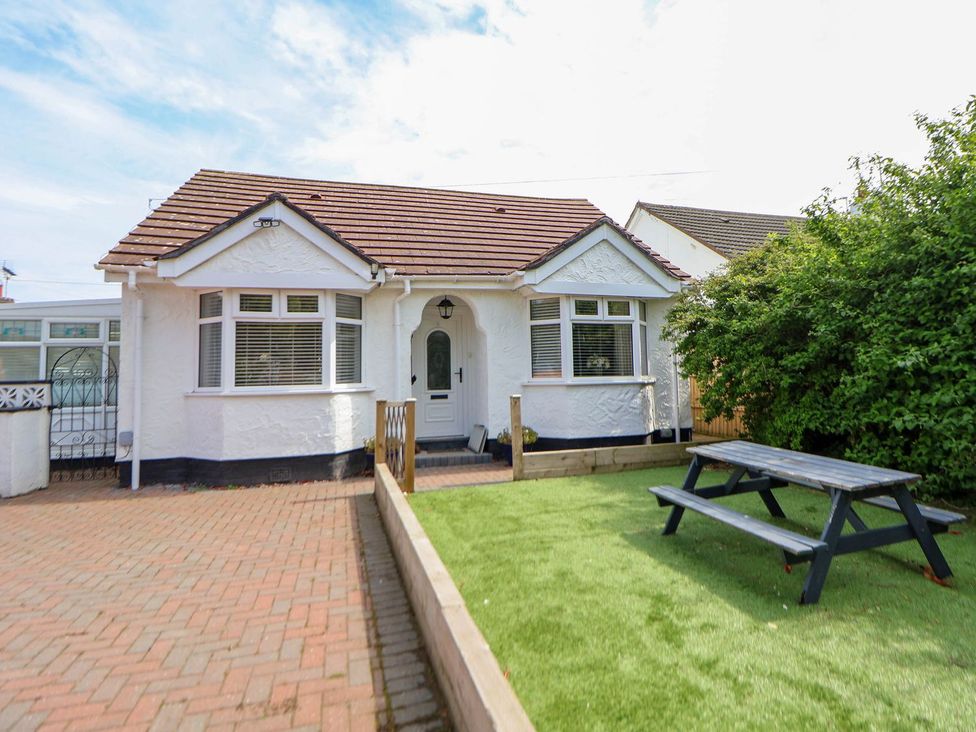 A bungalow with a picnic table in the front yard at Branwen in Talacre