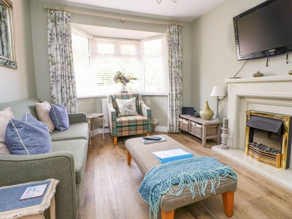 A living room with a sofa and television at Branwen in Talacre