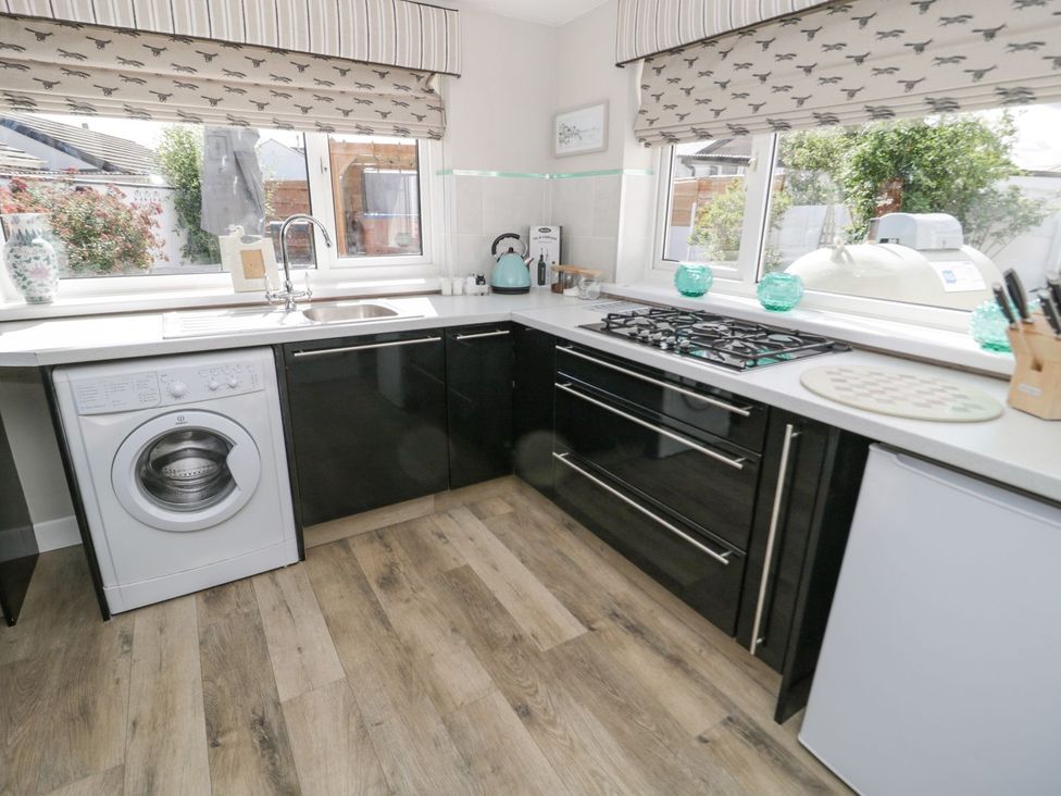 A kitchen with black cabinets and appliances at Branwen in Talacre