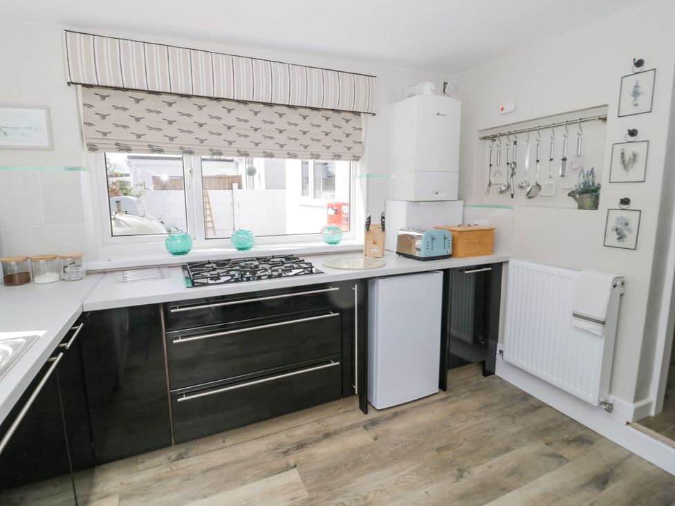 A kitchen with a gas stove and refrigerator at Branwen in Talacre