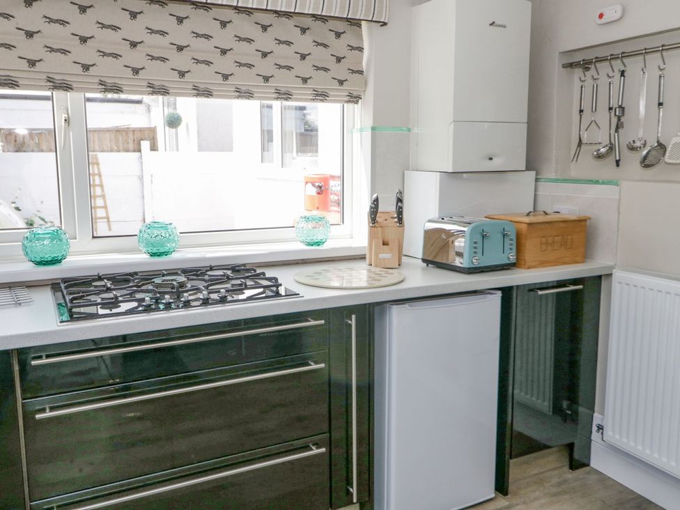 A kitchen with gas stove, fridge, toaster and utensils at Branwen in Talacre