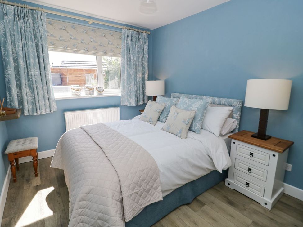 A bedroom with a bed and bedside tables at Branwen in Talacre