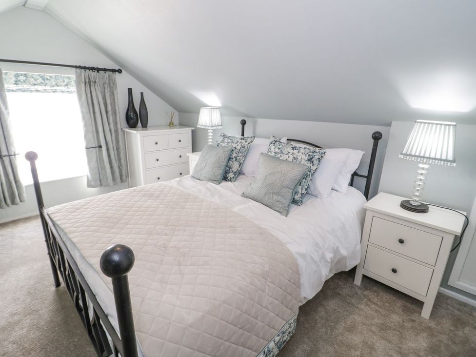 A bedroom with a bed and dresser at Branwen in Talacre