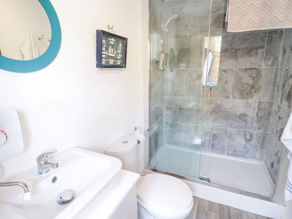 A bathroom with a wash basin and shower at Branwen in Talacre