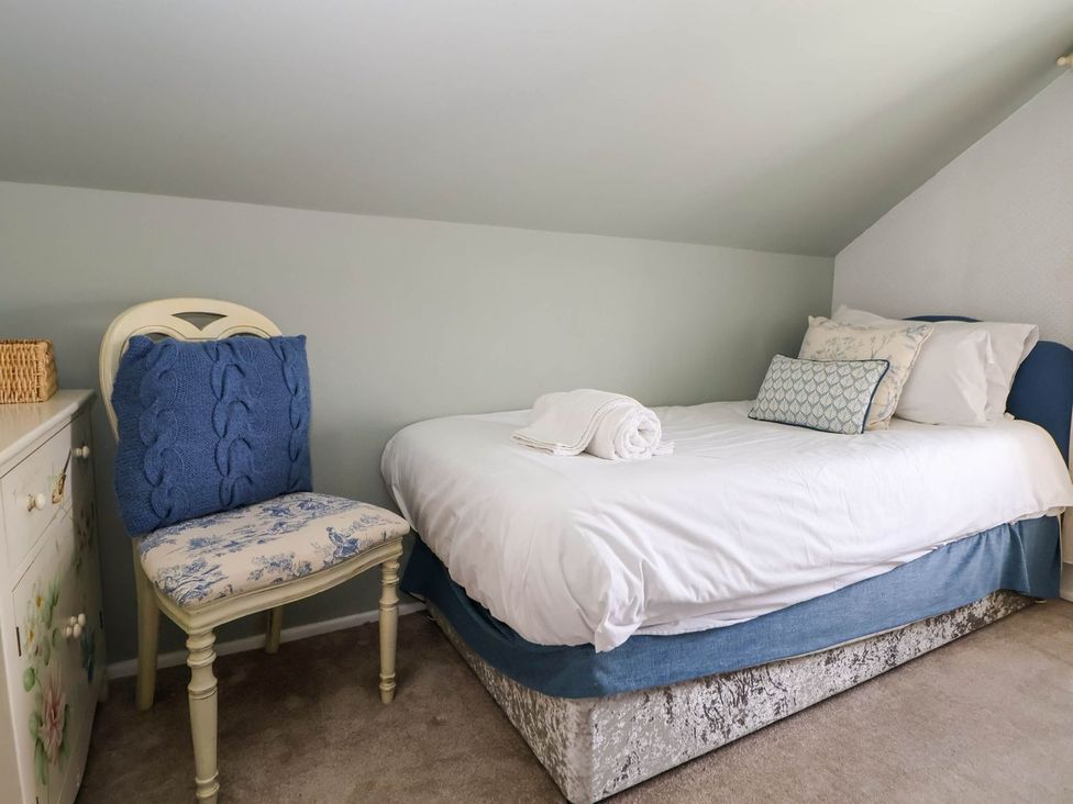 A bedroom with a bed and chair at Branwen in Talacre